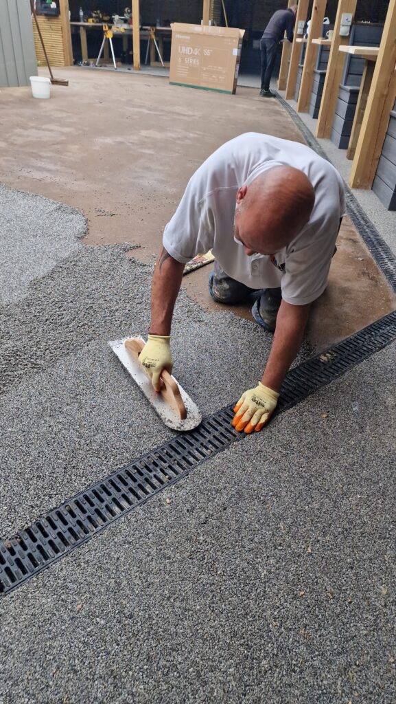 ACO drainage channel installed next to resin driveway-quality resin bound surface at a West Midlands pub beer garden.