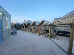 Aligned timber booth structures under construction on a prepared sub-base for resin driveway application