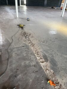 Cutting channel for electrical cables with a Kango hammer during self levelling epoxy resin floor installation in West Bromwich commercial space