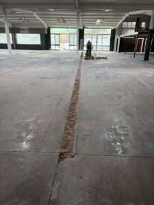 Long channel cut for electrical cables during self levelling epoxy resin floor installation in West Bromwich commercial space