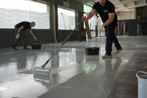 Close-up of roller applying UV-stable top coat to epoxy resin floor.