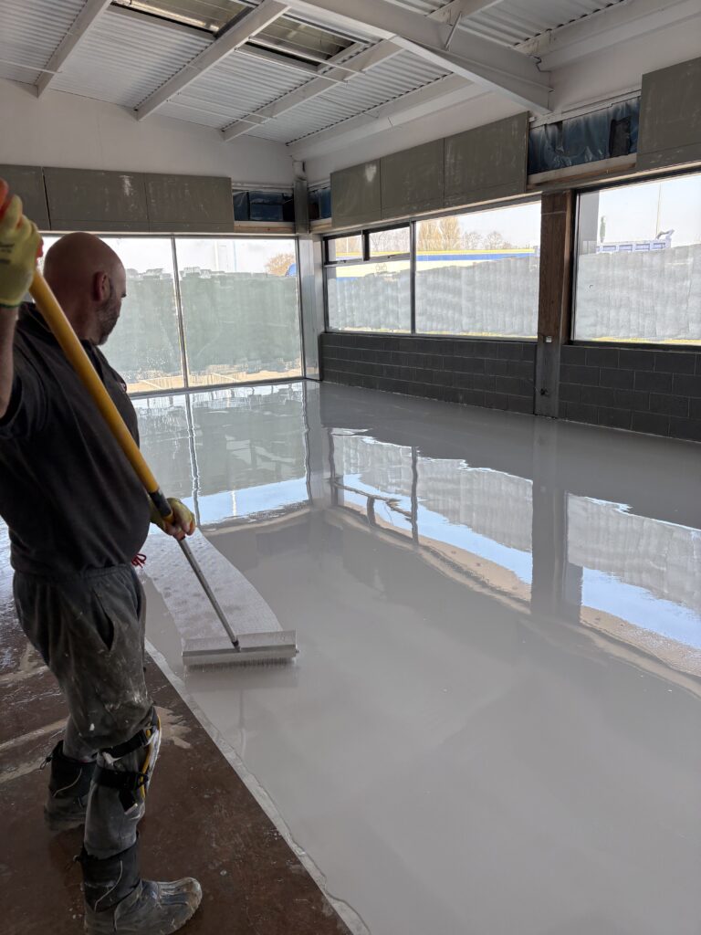 Lee Taylor MD applying UV-stable top coat with roller on self levelling epoxy resin floor.