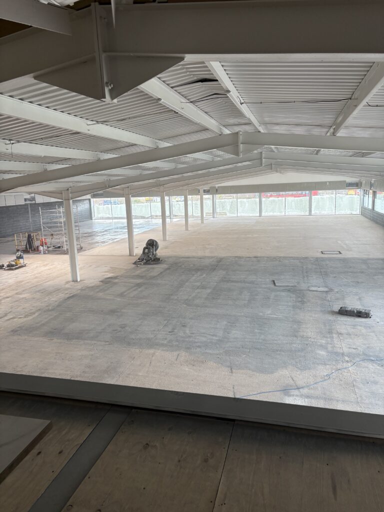 Smooth, level floor surface prepared and ready for DPM primer application during self levelling epoxy resin installation in West Bromwich commercial space