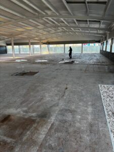 Uneven supermarket floor with rough surface before self levelling epoxy resin installation in West Bromwich