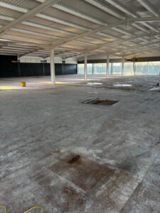 Supermarket floor showing manholes and uneven sections before self levelling epoxy resin installation in West Bromwich