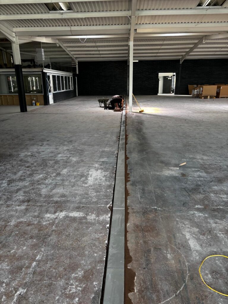 Neatly installed channel for electrical cables in West Bromwich supermarket self levelling epoxy resin floor