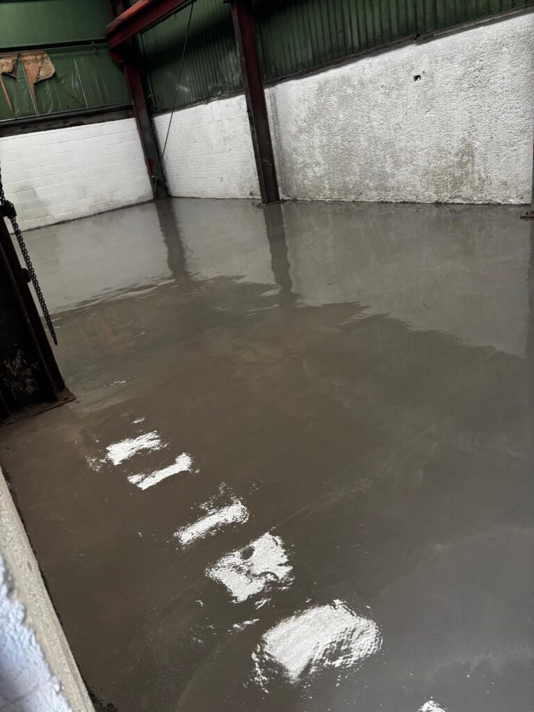 2mm epoxy screed being applied and trowelled across repaired concrete floor