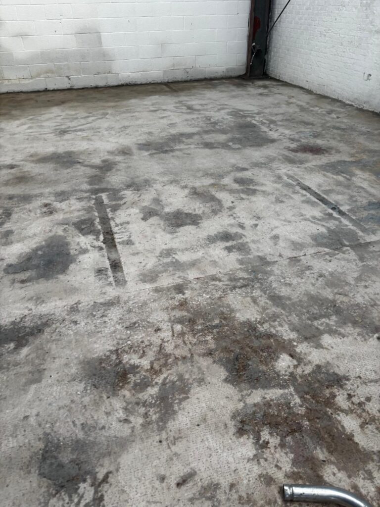 Industrial floor being mechanically scabbled and diamond ground to remove weak material and prepare substrate
