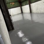 Finished high build epoxy resin floor with smooth, seamless, and durable surface in industrial workspace