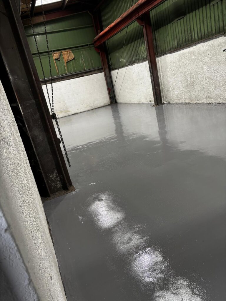 Finished high build epoxy resin floor with smooth, seamless, and durable surface in industrial workspace