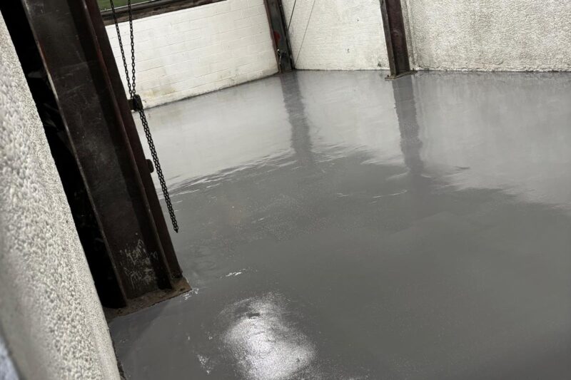 Finished high build epoxy resin floor with smooth, seamless, and durable surface in industrial workspace
