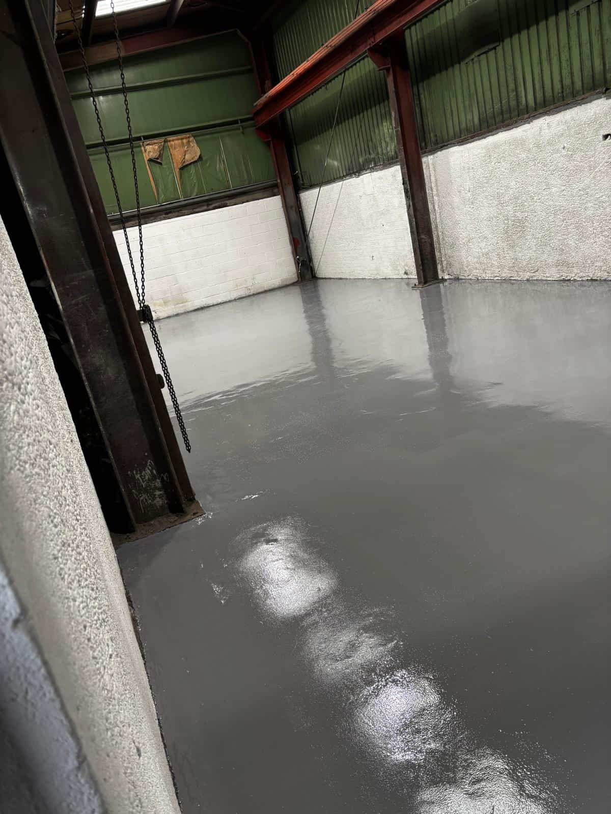 Finished high build epoxy resin floor with smooth, seamless, and durable surface in industrial workspace